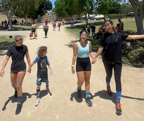 A group walking together outdoors, hand in hand